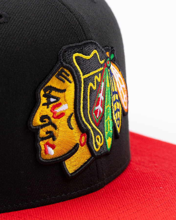 two tone red and black Mitchell &amp; Ness snapback with embroidered primary logo on front - front detail lay flat