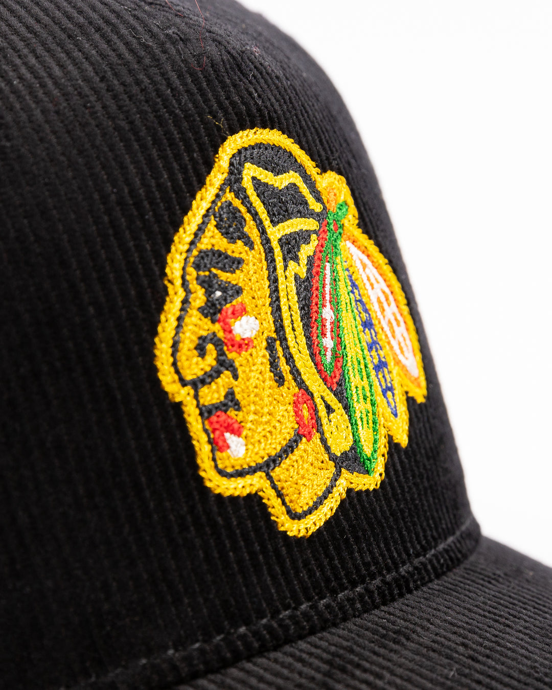 black corduroy snapback hat with chain stitch Chicago Blackhawks primary logo on front - front detail  lay flat