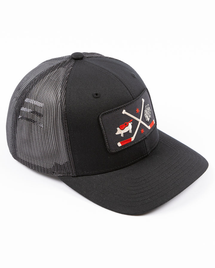 black trucker hat with patch of Windy City Smokeout logo and Chicago Blackhawks primary logo on front - right angle lay flat