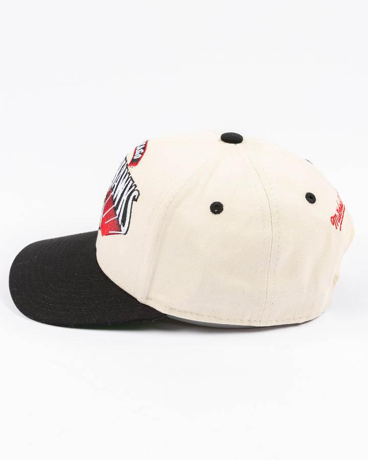 youth cream and black Mitchell & Ness snapback cap with Chicago Blackhawks wordmark and primary logo on front - left side lay flat