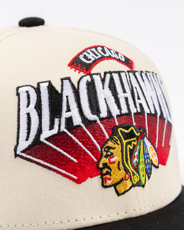 youth cream and black Mitchell & Ness snapback cap with Chicago Blackhawks wordmark and primary logo on front - detail lay flat