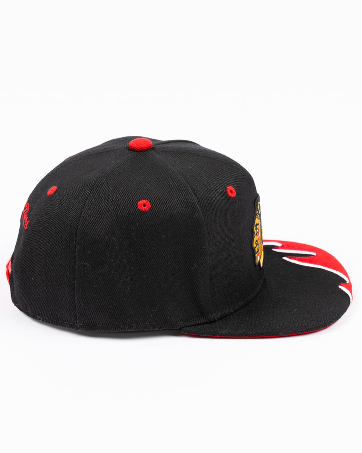 youth black MItchell & Ness snapback cap with Chicago Blackhawks primary logo on front and tide design embroidered on brim and left side - right side lay flat