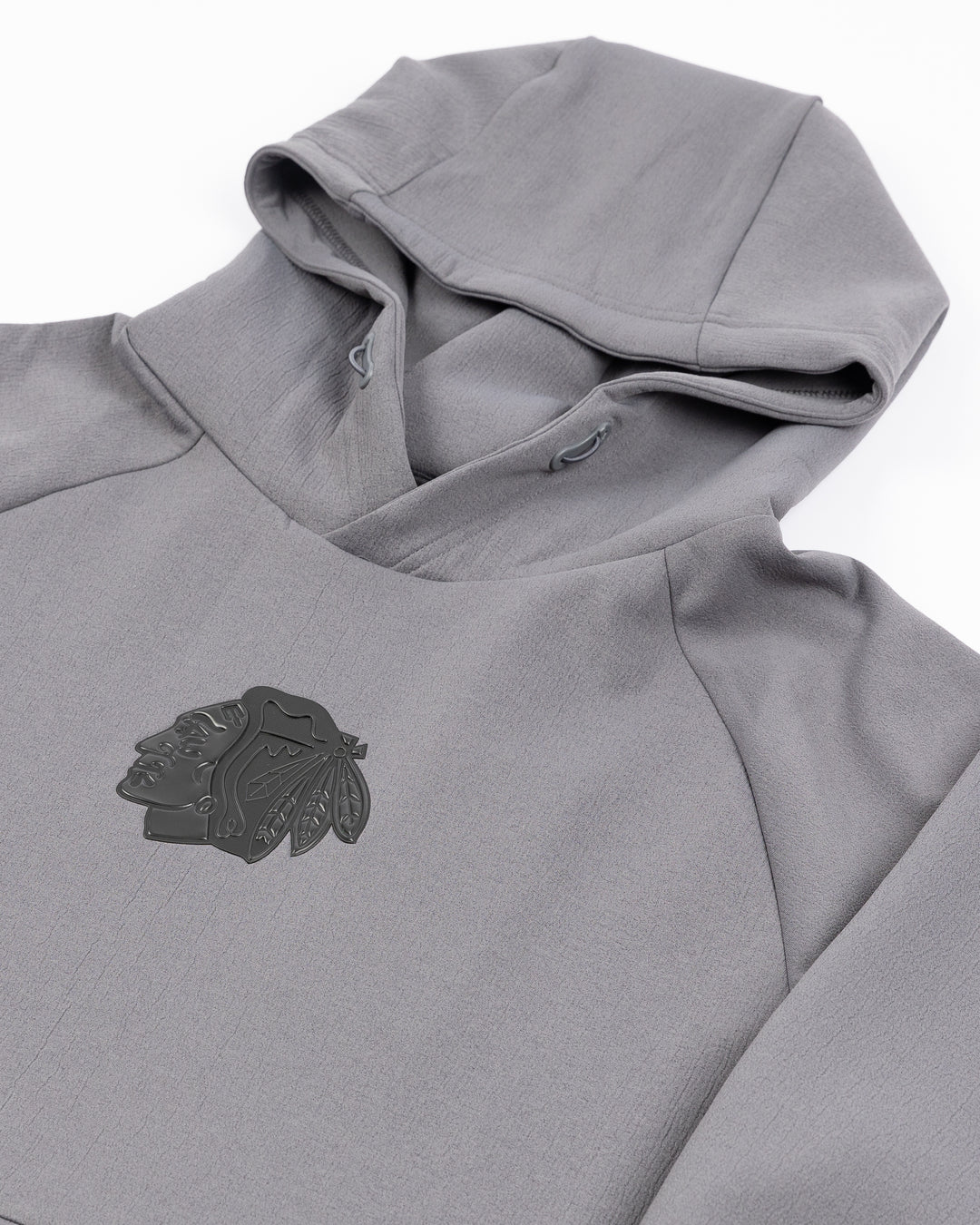 charcoal grey Loogaroo hoodie with tonal Chicago Blackhawks primary logo patch on center chest - detail lay flat