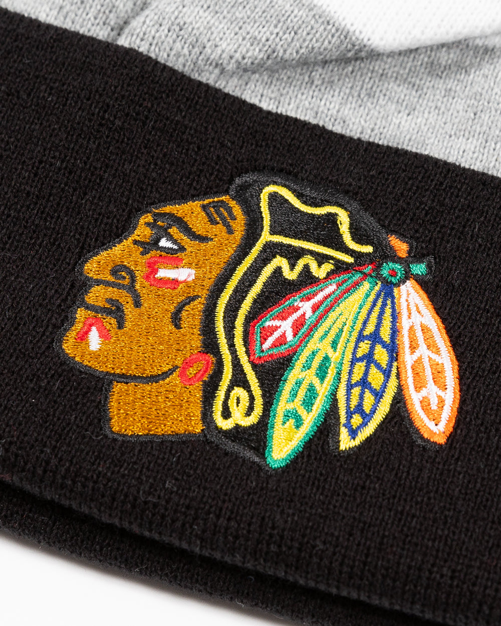 striped CCM knit hat with pom with Chicago Blackhawks primary logo embroidered on front cuff - detail lay flat