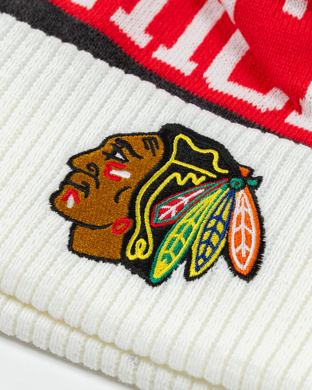 white CCM knit hat with pom with Chicago wordmark on front and Chicago Blackhawks primary logo embroidered on front cuff - detail lay flat