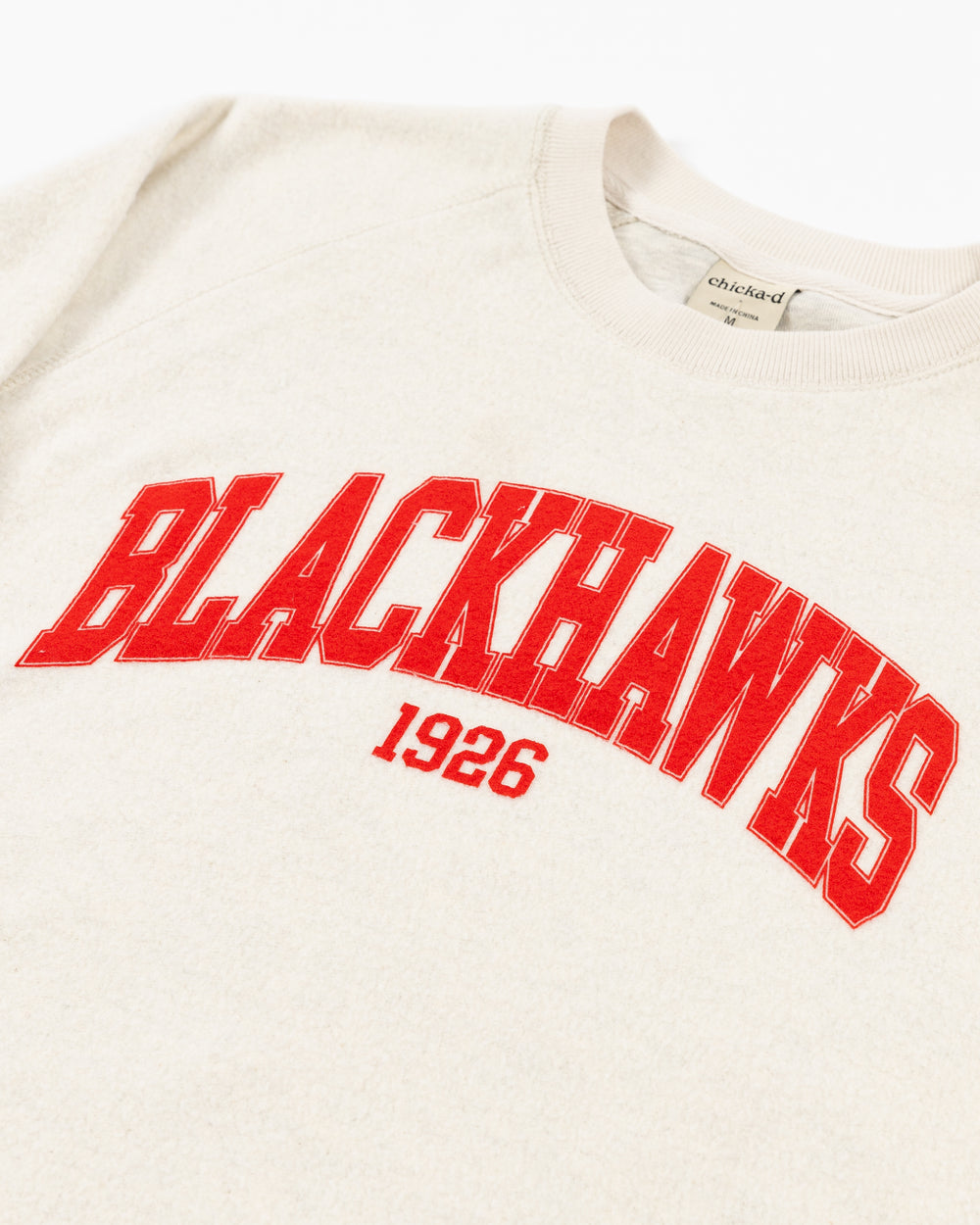 white chicka-d crewneck with Chicago Blackhawks wordmark in red across the chest - front detail lay flat