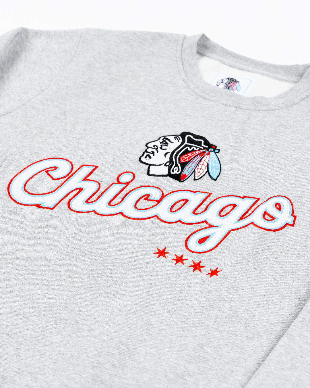 grey crewneck with Chicago script word graphic across front below Chicago Blackhawks primary logo in Chicago flag-inspired colorway - front detail lay flat