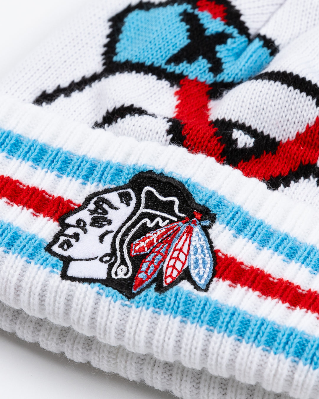 white knit pom hat with Chicago Blackhawks secondary logo on front and primary logo on striped cuff with multi color pom on top in Chicago flag-inspired colorway - front detail lay flat