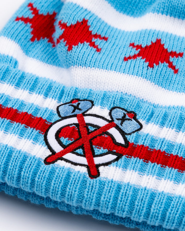 blue knit hat with Chicago flag-inspired design and Chicago Blackhawks secondary logo embroidered on front striped cuff and multicolor pom on top - front detail lay flat