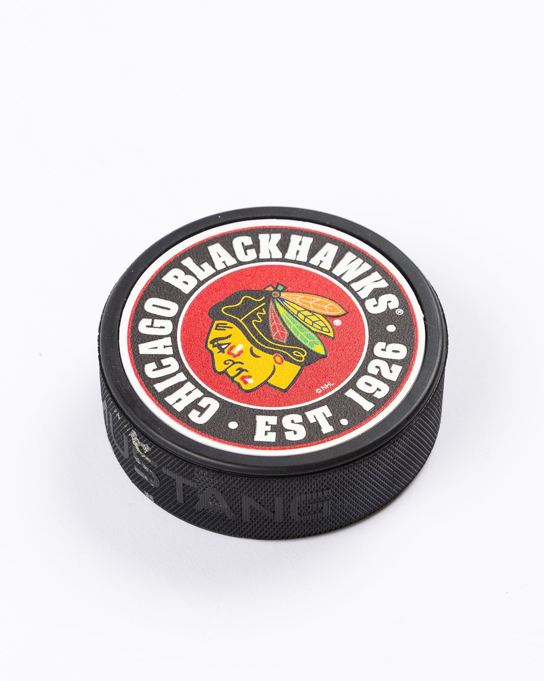 hockey puck with Chicago Blackhawks primary logo and established 1926 word graphic surrounding it - front angle lay flat
