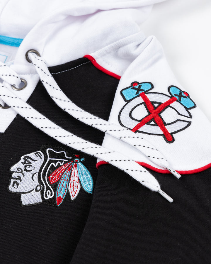 black and white lacer hoodie with diagonal Chicago wordmark on front with Chicago Blackhawks primary logo on left chest and secondary logos adorning shoulders - shoulder detail lay flat