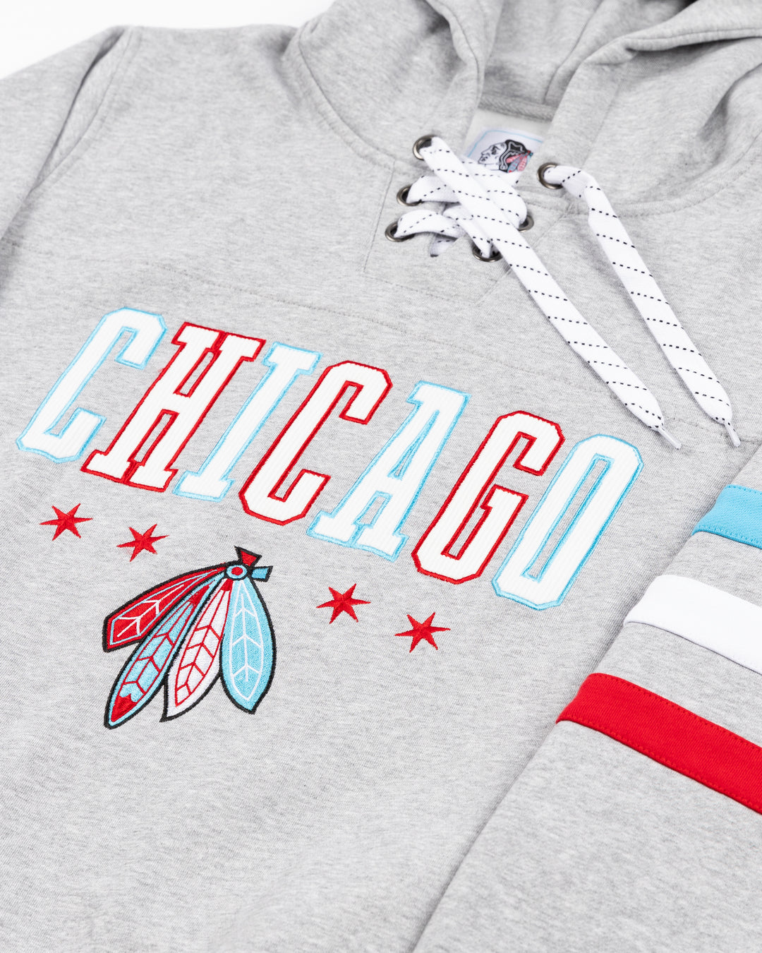 grey lacer hoodie with blue white and red stripes on arms with Chicago wordmark above Chicago Blackhawks four feather logo embroidered on front - front detail lay flat