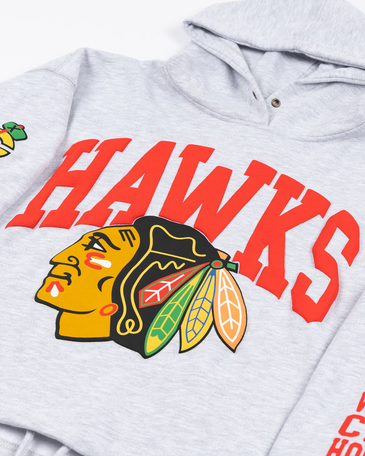 light grey women's '47 brand cropped hoodie with Chicago Blackhawks secondary logo on shoulder and wordmark and wrist with Hawks wordmark and primary logo on front - front detail lay flat