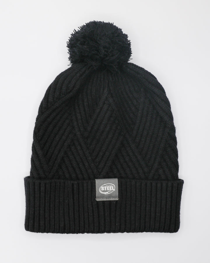 black cross-hatch knit pom beanie with small Chicago Steel tag on cuff - front lay flat