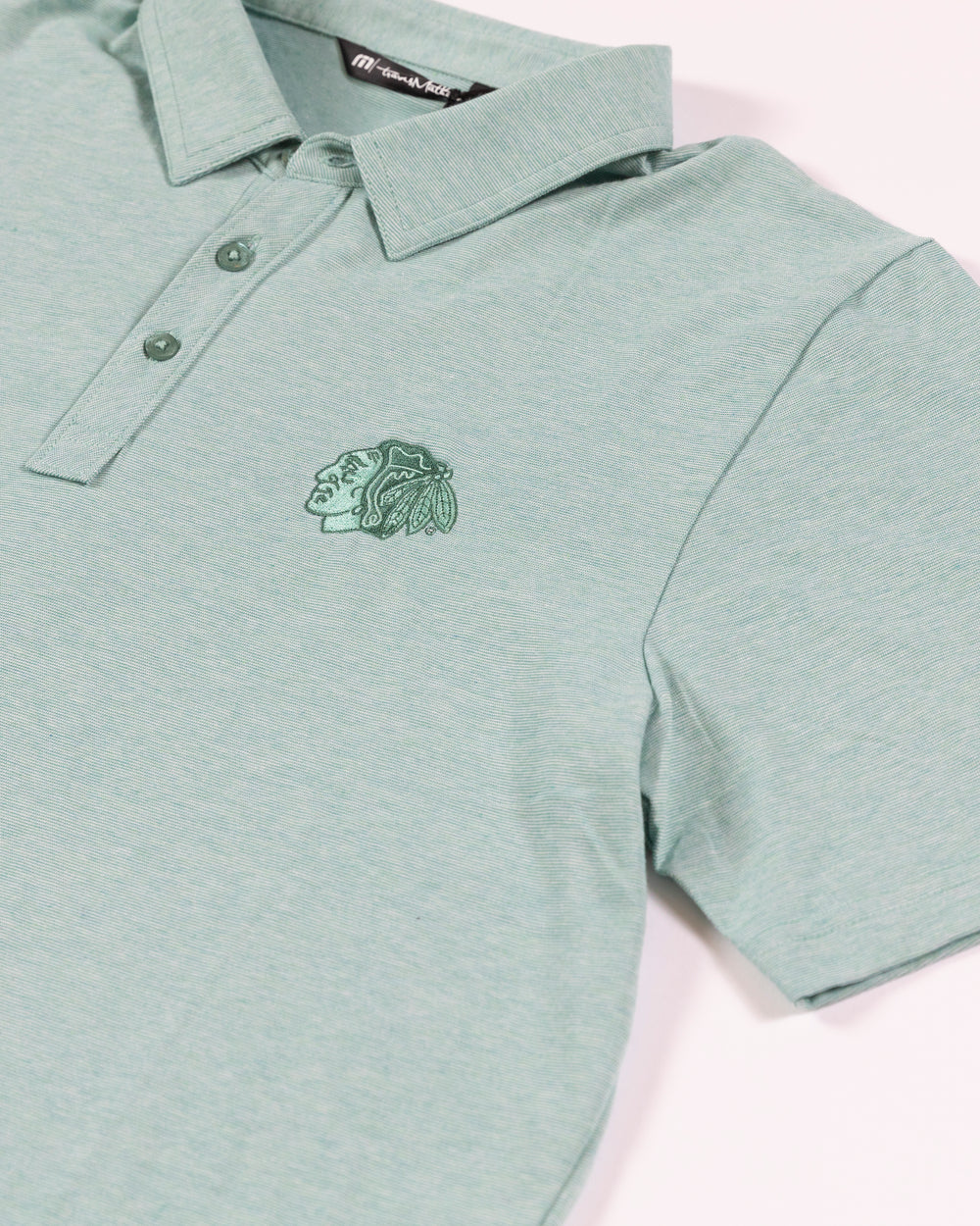 TravisMathew Chicago Blackhawks green polo with embroidered tonal primary logo - detail lay flat